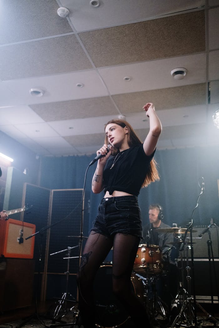 A dynamic live performance featuring a female singer in a studio setting with a live band.